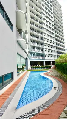 a swimming pool in front of a building at Design And Den - LK Urban Suites in Manila