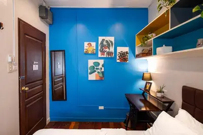 a bedroom with a blue wall with a desk at Homey and Cozey Poblacion Makati S07 in Manila