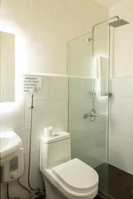 a bathroom with a toilet and a glass shower at Homey and Cozey Poblacion Makati S07 in Manila