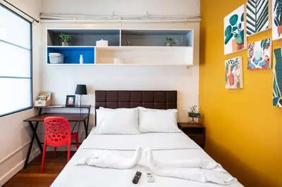 a bedroom with a bed and a desk with a red chair at Homey and Cozey Poblacion Makati S09 in Manila
