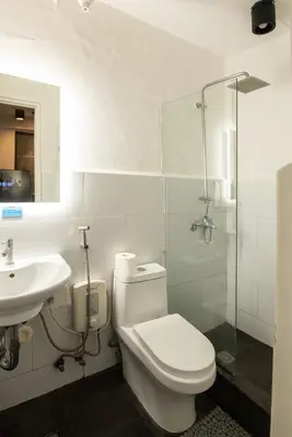 a bathroom with a toilet and a sink and a shower at Homey and Cozey Poblacion Makati S09 in Manila