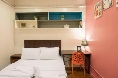 a bedroom with a bed and a desk with a chair at Homey and Cozey Poblacion Makati S10 in Manila