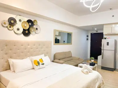 a bedroom with a large bed with plates on the wall at Elegant Venice Condo Mckinley Hill BGC #vlrtc5i in Manila