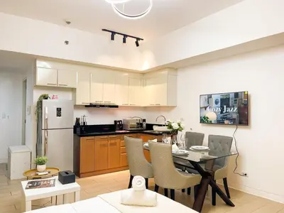 a kitchen and dining room with a table and chairs at Elegant Venice Condo Mckinley Hill BGC #vlrtc5i in Manila
