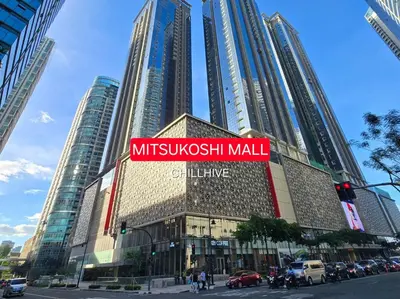 a building with a sign for a mitsubishi mall at Luxury BGC Condo Across Mitsukoshi #upt112b in Manila