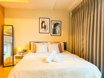 a bedroom with a large white bed and a mirror at Luxury BGC Condo Across Mitsukoshi #upt112b in Manila