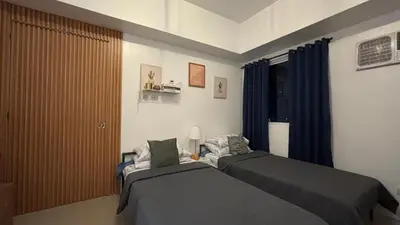a bedroom with two beds and a window at Calicon Suites in Manila