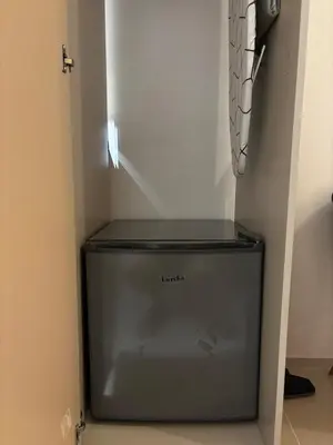 a small refrigerator in a corner of a room at Calicon Suites in Manila