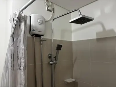 a shower with a shower head in a bathroom at Calicon Suites in Manila