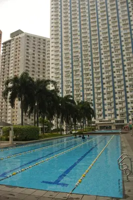a large swimming pool in front of tall buildings at Calicon Suites in Manila