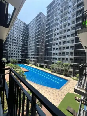 a balcony with a swimming pool in front of a large building at Casa Liandro in SMDC shore 3 in Manila