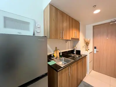 a kitchen with a sink and a refrigerator at Casa Liandro in SMDC shore 3 in Manila