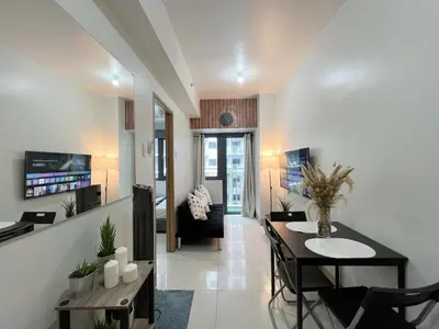 a living room with a table and a dining room at Casa Liandro in SMDC shore 3 in Manila
