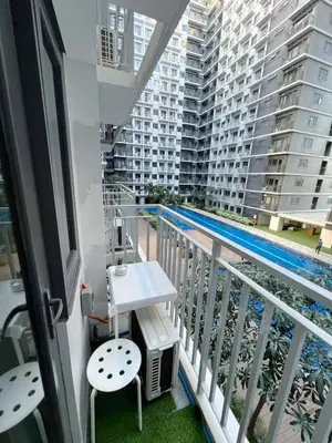 a balcony with a table and a swimming pool at Casa Liandro in SMDC shore 3 in Manila