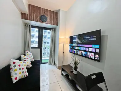 a living room with a flat screen tv on the wall at Casa Liandro in SMDC shore 3 in Manila