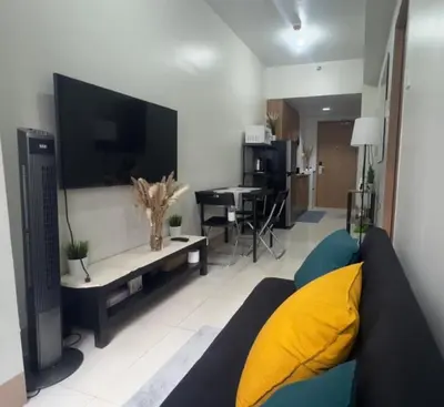 a living room with a couch and a flat screen tv at Casa Liandro in SMDC shore 3 in Manila