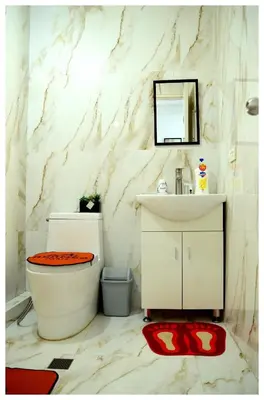 a bathroom with a toilet and a sink and a mirror at Brianna's haven property rental in Manila