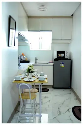 a small kitchen with a table and a refrigerator at Brianna's haven property rental in Manila