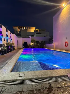 a swimming pool at night with a building at Your perfect retreat in Stamford! Enjoy our stylish, fully furnished studio just steps away from the vibrant Venice Mall in Manila