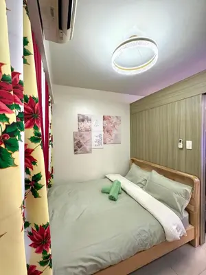 a bedroom with a large bed with a light at Santa Place Shore Residences Tower A in Manila