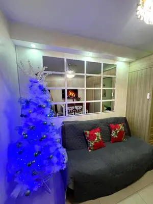 a blue christmas tree in a living room with a couch at Santa Place Shore Residences Tower A in Manila