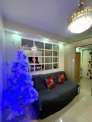 a blue christmas tree in a living room with a couch at Santa Place Shore Residences Tower A in Manila