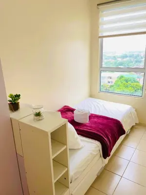 a small bedroom with a bed and a window at DJ Apartment in Manila