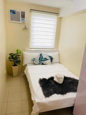 a bed in a room with a window at DJ Apartment in Manila