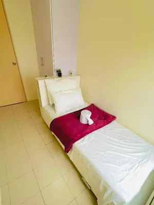 a bed with a stuffed animal on a red blanket at DJ Apartment in Manila
