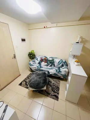 a room with a bed in the corner of a room at DJ Apartment in Manila