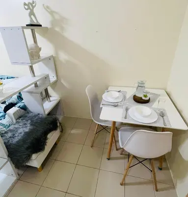 a kitchen with a table and two chairs and a table and chairsktop at DJ Apartment in Manila