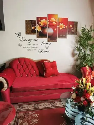a red couch in a living room with pictures on the wall at Sweetheart Casa Vacanza in Manila