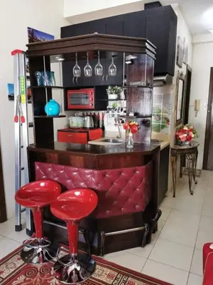 a kitchen with a bar with red stools in it at Sweetheart Casa Vacanza in Manila