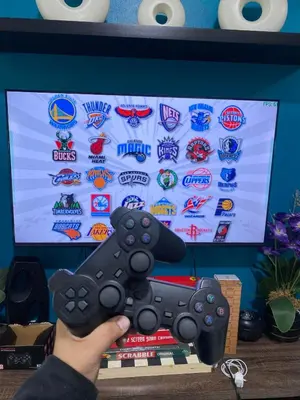 a person holding a video game controller in front of a tv at Cozy Inn Azure in Manila