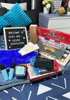 a table with a pile of books and cell phones at Cozy Inn Azure in Manila
