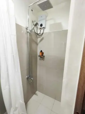 a shower with a shower curtain in a bathroom at Shore 2 Residences by Casa Stellar in Manila