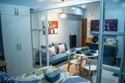 a living room with a table and a couch at Elivion Staycations at McKinley Hill, near Venice, BGC, with Pool & Wifi in Manila