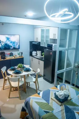 a kitchen and living room with a table and chairs at Elivion Staycations at McKinley Hill, near Venice, BGC, with Pool & Wifi in Manila