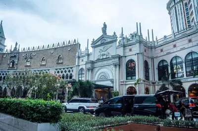 a large building with cars parked in front of it at Elivion Staycations at McKinley Hill, near Venice, BGC, with Pool & Wifi in Manila