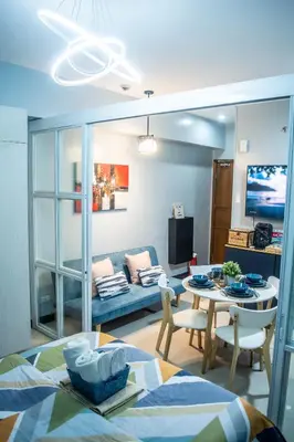 a living room with a table and a couch at Elivion Staycations at McKinley Hill, near Venice, BGC, with Pool & Wifi in Manila