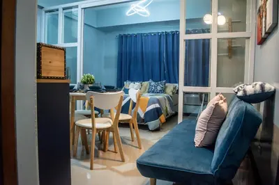 a room with a couch and a bed and a table at Elivion Staycations at McKinley Hill, near Venice, BGC, with Pool & Wifi in Manila