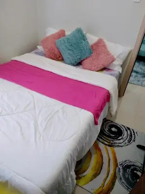a bed with colorful pillows on top of it at A & Y Staycation in Manila