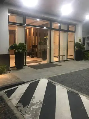 a large building with glass doors and a potted plant at A & Y Staycation in Manila
