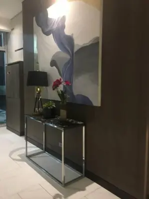 a table in a room with a painting on the wall at A & Y Staycation in Manila