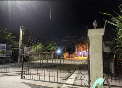 a wrought iron fence with a gate at night at Family Airconditioned Room with Balcony & Parking in Cabuyao 2-storey house in Cabuyao