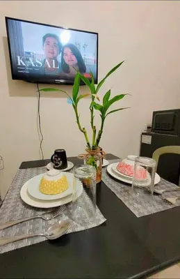 a table with two plates of food and a television at Sea Residences MOA by -MJ in Manila