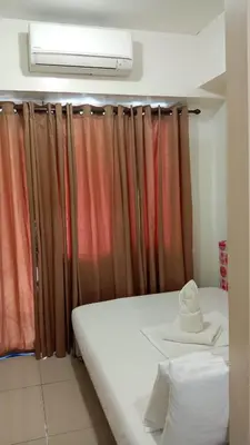 a room with a bed and a window with curtains at Sea Residences MOA by -MJ in Manila