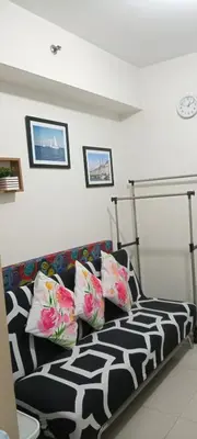 a living room with a black and white couch with pillows at Sea Residences MOA by -MJ in Manila