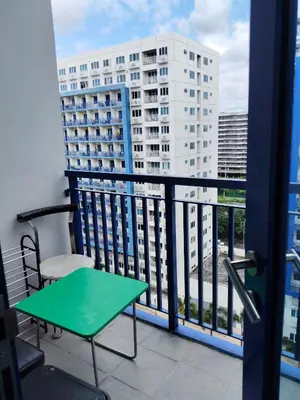 a balcony with a green table and a chair at Sea Residences MOA by -MJ in Manila