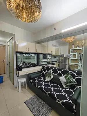 a living room with a large bed and a kitchen at Sea Residences MOA by -MJ in Manila